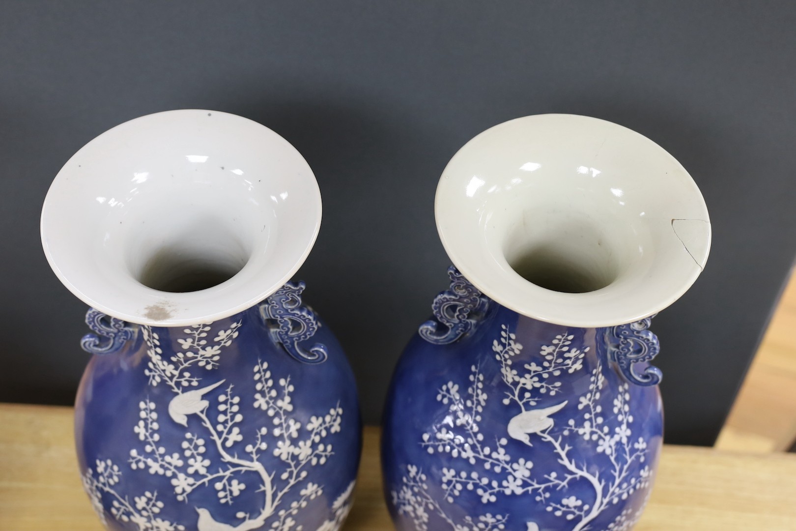 A pair of large 19th century Chinese slip decorated blue ground vases, restored, 59cm